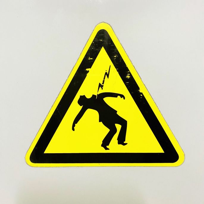 Photo d'un panneau avertissant du danger électrique présent dans un local technique de l'université