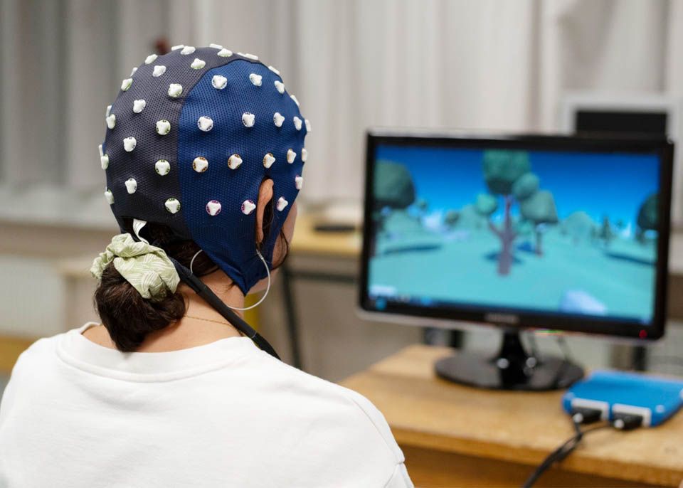 Camille Jeunet-Kelway équipée d'un casque munis de capteurs enregistrant l'activité électrique cérébrale, utilisé pour piloter une interface numérique © Arnaud Rodriguez - Bordeaux Neurocampus