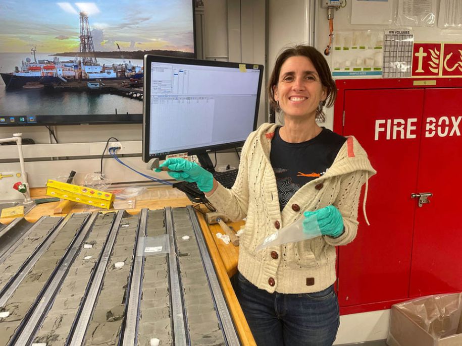 Emmanuelle Ducassou, co-responsable scientifique de la mission océanographique IODP, prélève un échantillon  à partir d’une carotte de sédiment en janvier 2024. © Simon George & IODP